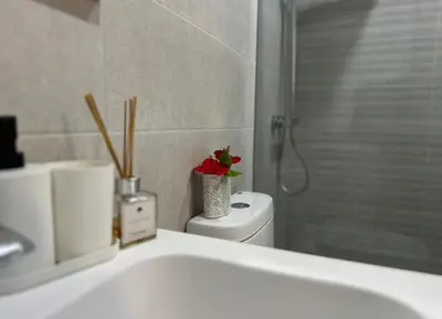 a bathroom with a sink and a toilet with a flower on it at A104 - PRADOS · Peaceful 2BR Poolside Retreat • Punta Cana Getaway in Punta Cana