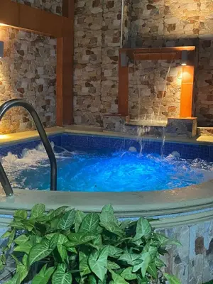 a hot tub in a resort with blue water at Constanza Family House in Constanza