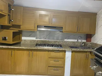 a kitchen with wooden cabinets and a sink at Constanza Family House in Constanza