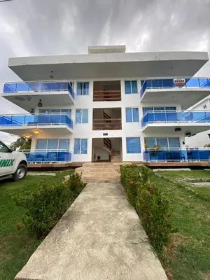 a white building with blue balconies and a parking lot at A space designed for you in San Cristóbal