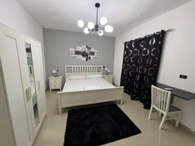 a bedroom with a bed and a chair and a chandelier at Quiet and beautiful view in Boca Chica