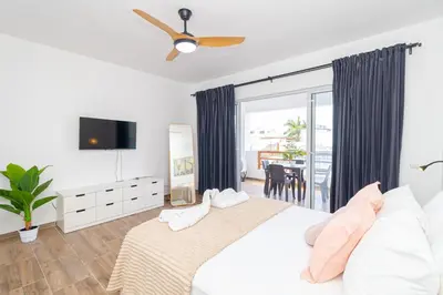 a bedroom with a white bed with a ceiling fan at Luxury 1 BR at Paraiso Residence Bayahibe in Bayahibe