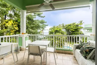 a porch with a couch and a table and chairs at Galeria Beach Front, Top floor in Sosúa