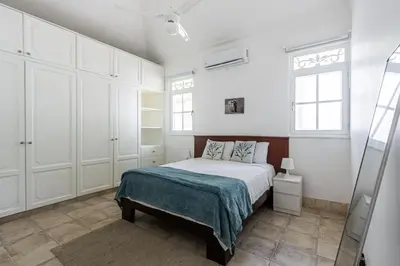 a bedroom with a bed and white cabinets at Galeria Beach Front, Top floor in Sosúa