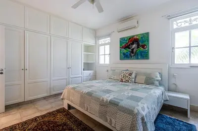 a bedroom with a bed and a painting on the wall at Galeria Beach Front, Top floor in Sosúa