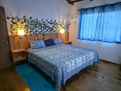 a bedroom with a bed and two lamps and a window at Casa vista hermosa in Camú