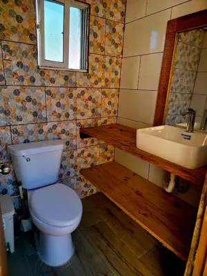 a bathroom with a toilet and a sink at Casa vista hermosa in Camú