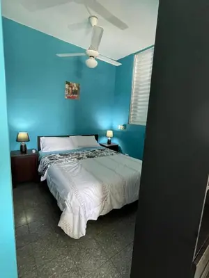 a blue bedroom with a bed and a ceiling fan at Espacio Santa Bárbara, Zona Colonial in Santo Domingo