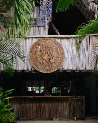 a gold plate hanging on a wall with plants at Ganesh Village Community in Colorado