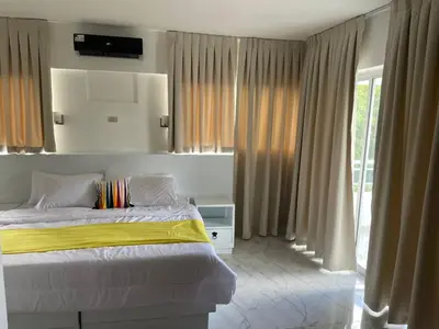 a bedroom with a bed with a yellow blanket at Zile Hotel in Boca Chica