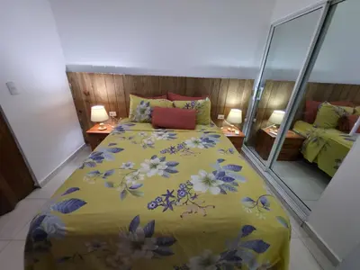 a bedroom with a yellow bed with flowers on it at Playa y arena in San Felipe de Puerto Plata