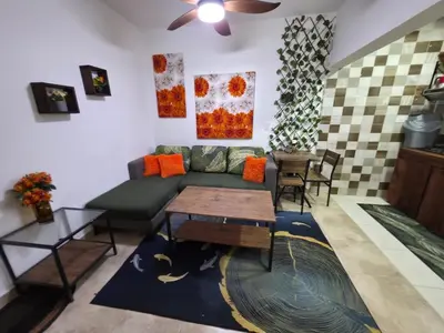 a living room with a green couch and a table at Playa y arena in San Felipe de Puerto Plata