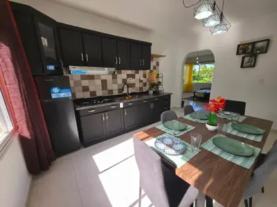 a kitchen with a wooden table and a dining room at Brisa de mar in San Felipe de Puerto Plata