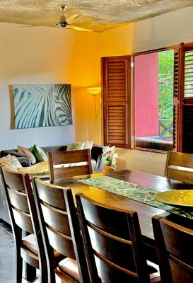 a dining room with a wooden table and chairs at Hostal Luz Del Valle in Santa Bárbara de Samaná