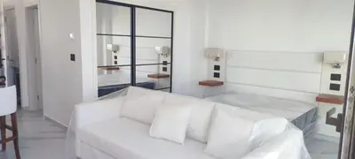 a white living room with a white couch and a mirror at Penthouse in Cana Rock in Punta Cana