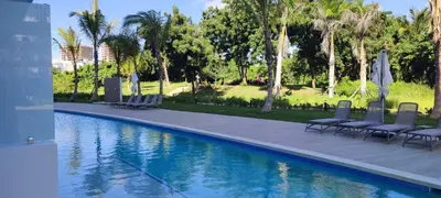 a swimming pool with chairs and palm trees at Penthouse in Cana Rock in Punta Cana