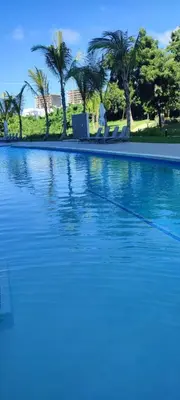 a swimming pool with blue water and palm trees at Penthouse in Cana Rock in Punta Cana