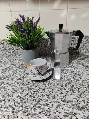 a coffee maker and a cup on a counter with flowers at Comfortable and quiet double room in Santo Domingo