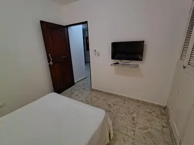 a bedroom with a bed and a flat screen tv at Comfortable and quiet double room in Santo Domingo