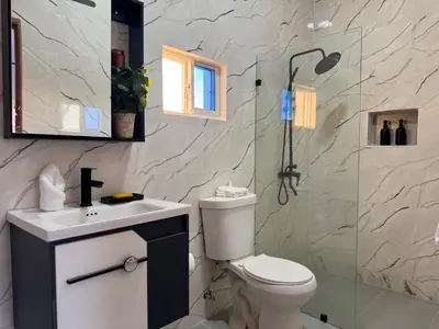 a bathroom with a shower and a toilet and a sink at Terra Mia Villa in Pedernales