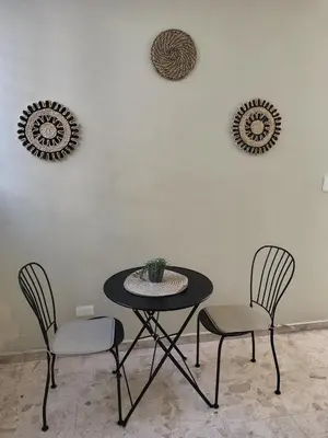 a table and two chairs with a plant on a wall at Private and comfortable double room in Santo Domingo