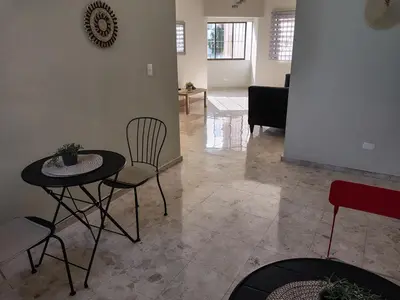 a living room with a table and chairs at Private and comfortable double room in Santo Domingo