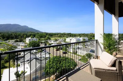 a balcony with chairs and a view of a city at Cozy 2BD Condo, Near Beach in San Felipe de Puerto Plata