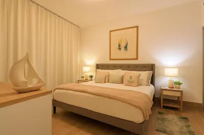 a bedroom with a large bed with two night stands and two lamps at Cozy 2BD Condo, Near Beach in San Felipe de Puerto Plata