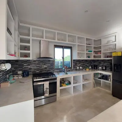a large kitchen with white cabinets and a stove at Villa Olam in Las Galeras
