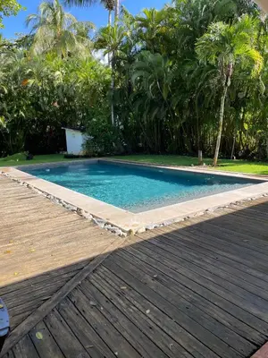 a swimming pool next to a wooden deck at Villa Louana in Las Terrenas