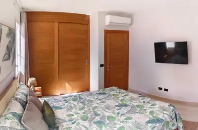 a bedroom with a bed and a tv on the wall at Green Oasis in La Laguna
