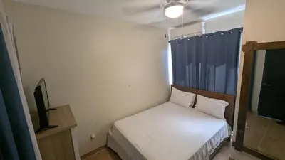 a small bedroom with a bed and a television at Villa soñada 1 in Sosua