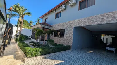 a building with a garage and a palm tree at Villa soñada 1 in Sosua