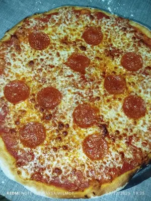 a pepperoni pizza sitting on top of a table at Parador tropical in Las Galeras