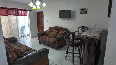 a living room with a couch and chairs and a table at Garden Mar in Bonao