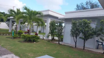 a white house with palm trees and a yard at This beautiful apt you can have a nice vacation in Santo Domingo