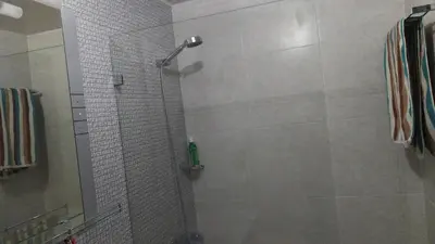 a shower with a glass door in a bathroom at This beautiful apt you can have a nice vacation in Santo Domingo