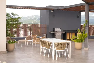 a group of tables and chairs on a patio at Modern & Cozy Luxury Suite with Amazing Views of STI in Santiago de los Caballeros