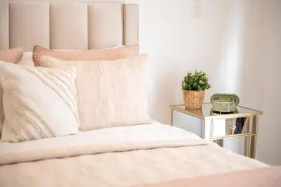 a bedroom with a bed with a plant on a night stand at Modern & Cozy Luxury Suite with Amazing Views of STI in Santiago de los Caballeros