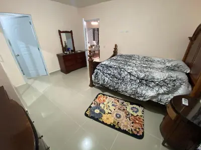 a bedroom with two beds and a mirror and a rug at Casa amarilla in La Romana