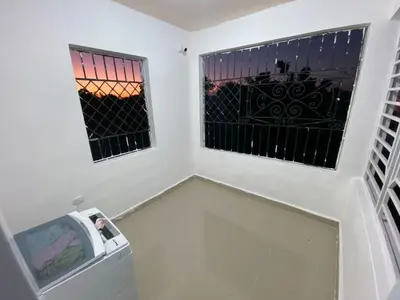 a room with two windows and a trash can at Casa amarilla in La Romana
