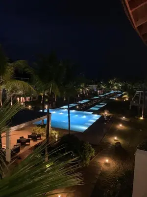 a large swimming pool at night with lights at Beachfront Sublime Las Terrenas in Las Terrenas