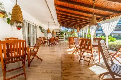 a restaurant with wooden chairs and tables and windows at Beachfront Sublime Las Terrenas in Las Terrenas