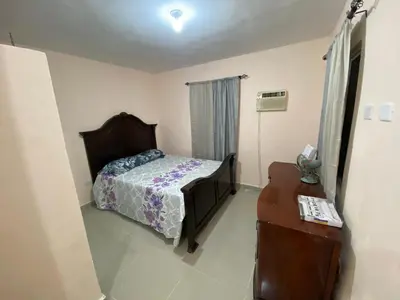 a bedroom with a bed and a dresser and a table at Casa amarilla in Cumayasa Kilómetros 4 1/2