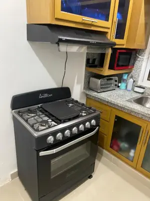a kitchen with a black stove and a sink at Casa amarilla in Cumayasa Kilómetros 4 1/2