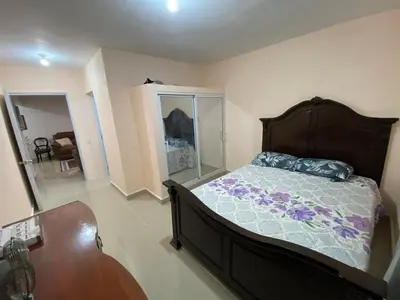 a bedroom with a bed and a dresser and a table at Casa amarilla in Cumayasa Kilómetros 4 1/2
