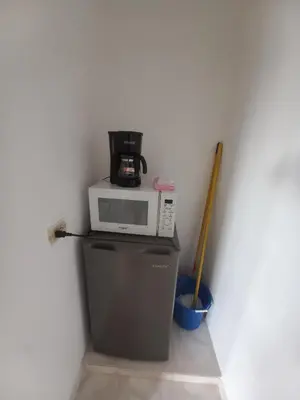 a microwave on top of a refrigerator with a coffee maker at Casa Petter and Maria, 2end floor in Santiago de los Caballeros
