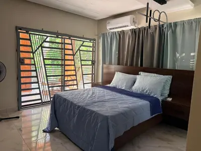 a bedroom with a bed and a large window at Villa Rafael in Bayaguana