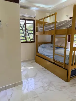 a bedroom with bunk beds in a room with a tile floor at Villa Rafael in Bayaguana