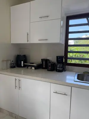a kitchen counter with white cabinets and a sink at Villa Rafael in Bayaguana